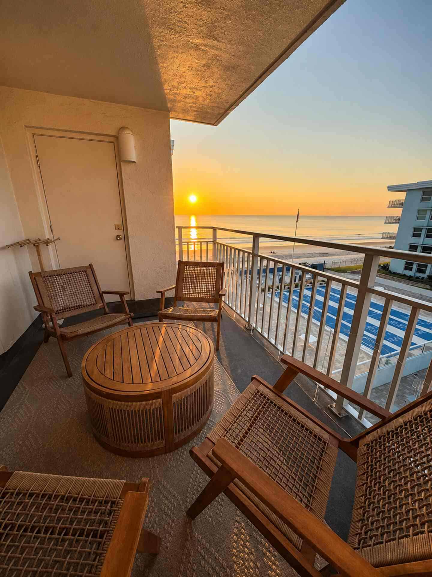 Balcony with seating overlooking ocean at sunset in New Smyrna Beach.