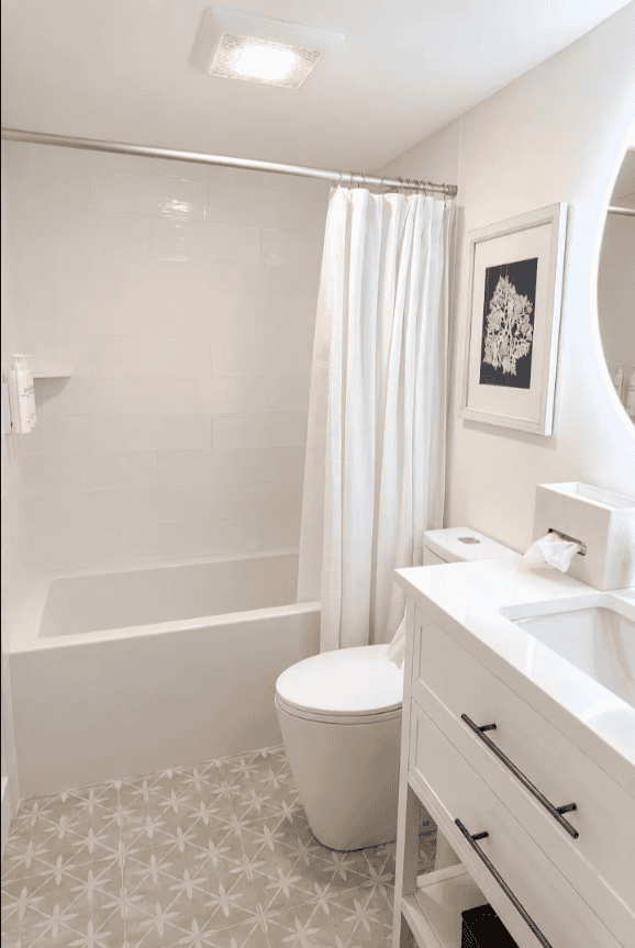Bright guest bathroom with tub and shower at Salt & Vine Beach House in New Smyrna Beach, Florida