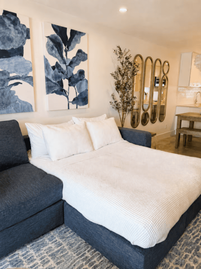 Queen sleeper sofa converted into a bed in the living room at Salt & Vine Beach House in New Smyrna Beach, Florida