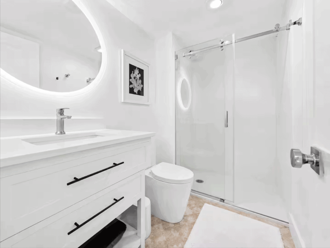 Bright primary bathroom with glass walk-in shower at Salt & Vine Beach House in New Smyrna Beach, Florida